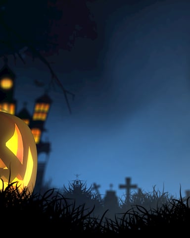 Glowing jack-o'-lantern in grass at night with haunted house and moon in background