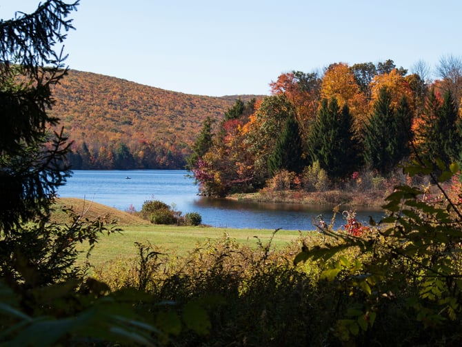 Pennsylvania lake framed by autumn foliage in orange and red