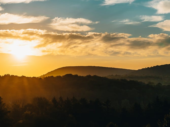Golden sunrise over rolling Pennsylvania mountain ridges with dramatic clouds