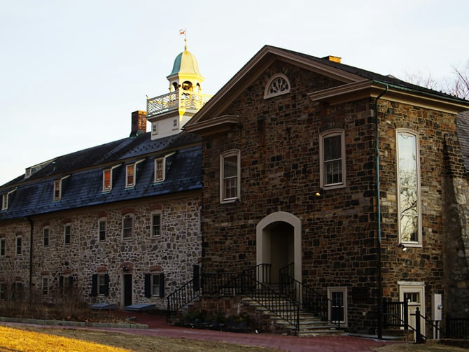 Old stone building with copper-domed clock tower against a winter sky